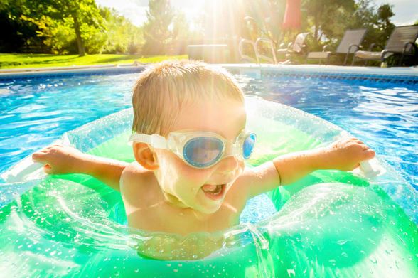 a young boy swimming in a pool of water